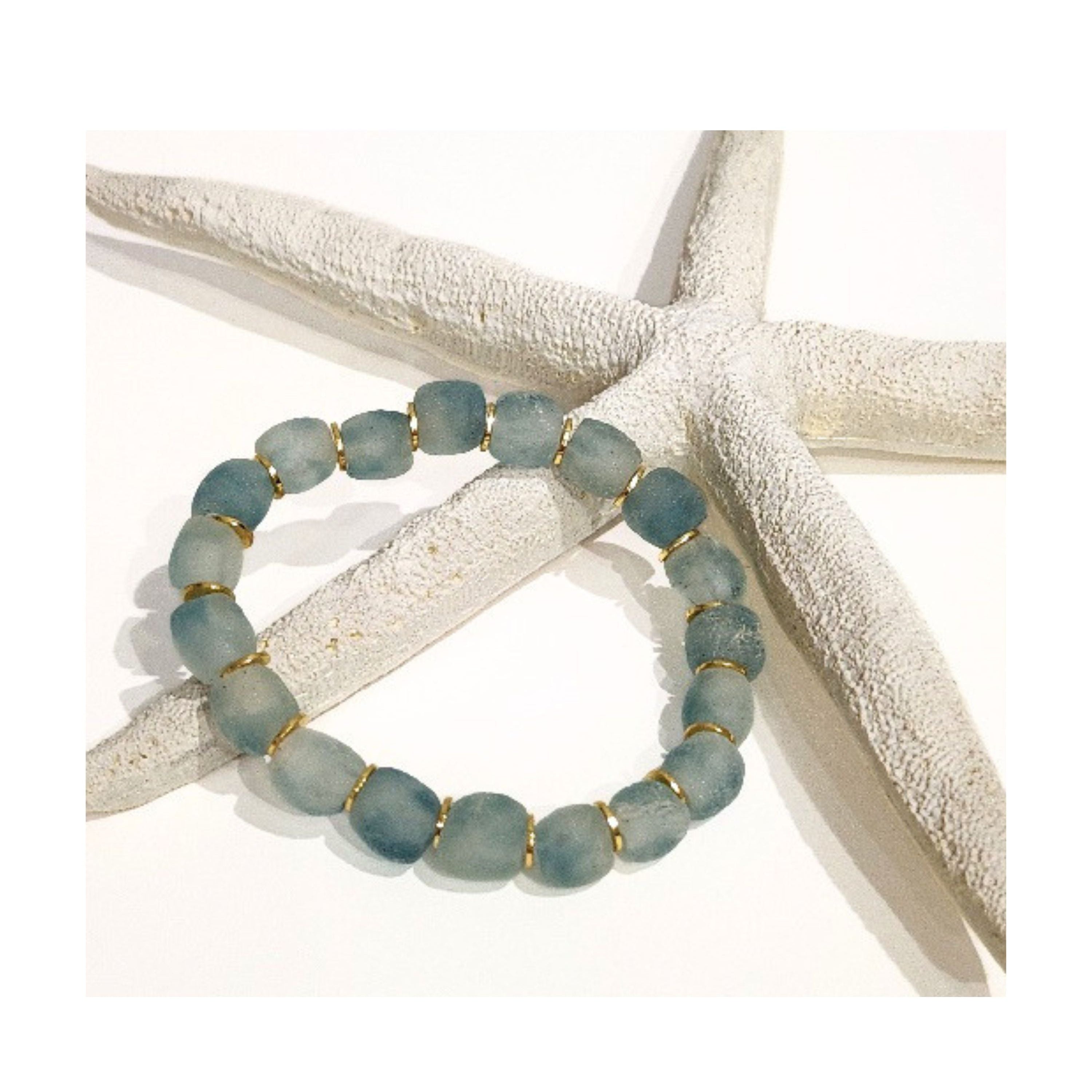 9mm Blue Wave Marine recycled glass bead bracelet with gold spacers displayed on a natural white starfish against clean white background
