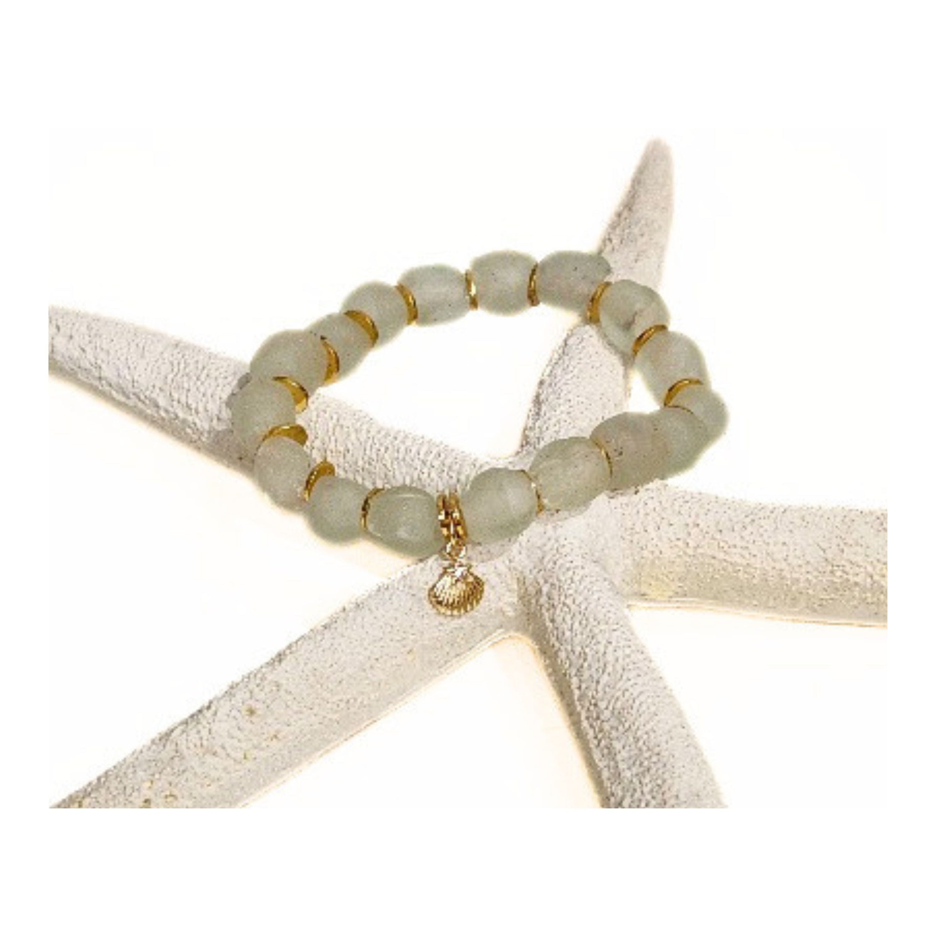 9mm clear aqua recycled glass bracelet with gold spacers and a petite gold shell charm featuring a tiny sparkling cz star displayed on a white starfish against a clean white background