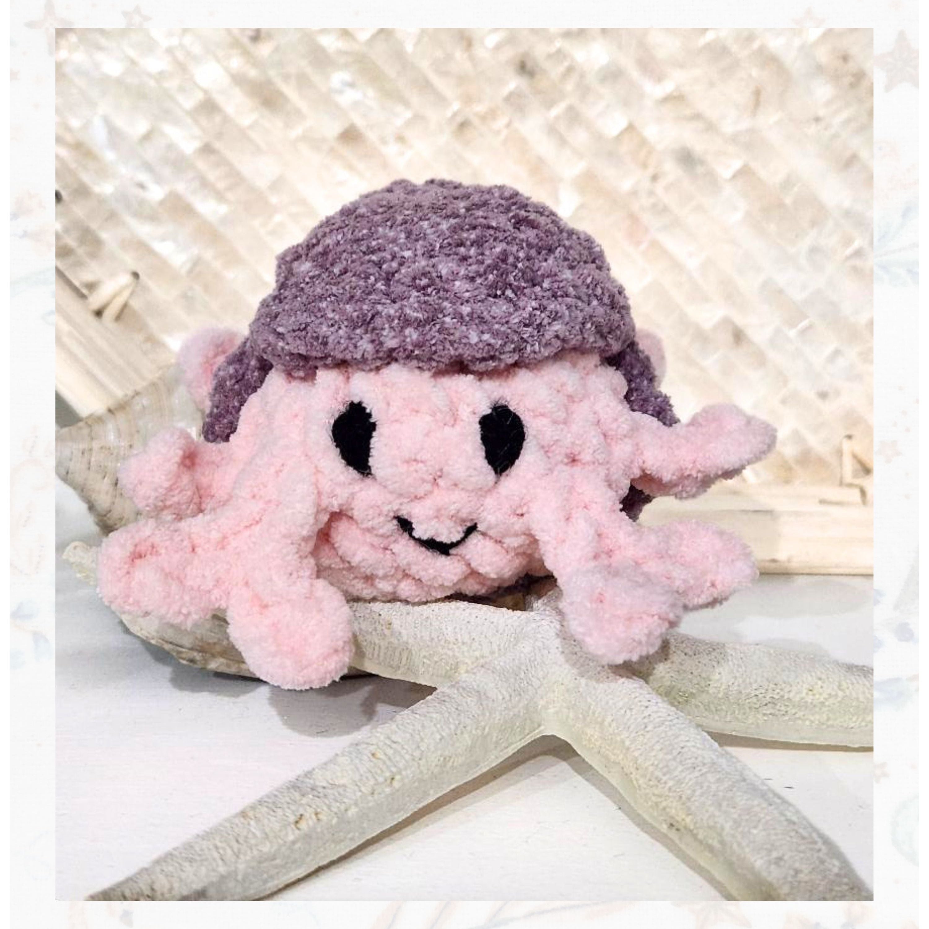 Handmade crochet crab from the Rainbow  Rover collection featuring a vibrant pink body and a dapper purple sun hat, handcrafted in Beaufort SC by Coastline Boutique