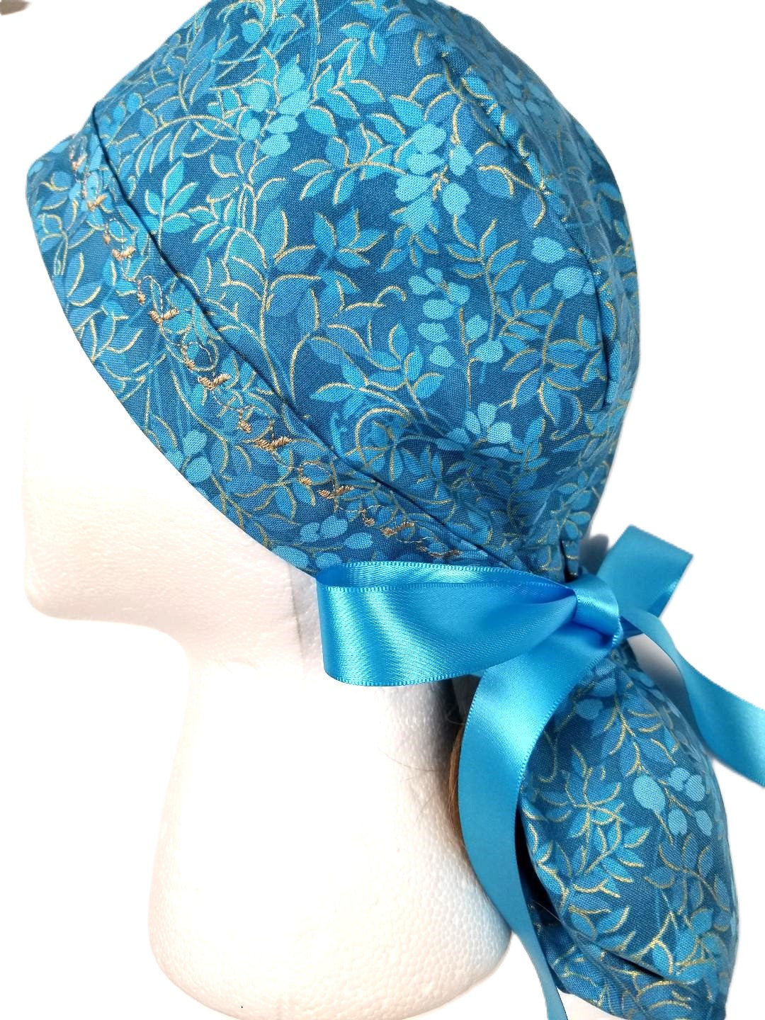 Gilded Turquoise ponytail surgical cap with elegant gold swirls of berry motifs, paired with designer-stitched headband by Coastline Boutique