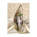 A handcrafted tall gilded oyster shell ornament featuring a front facing mama and baby African elephant design with subtle gold sparkle and green tree details. Staged on a signature background of white coral and a starfish, finished with a white and gold trimmed satin ribbon. 